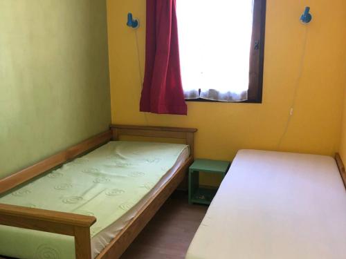 deux lits dans une petite pièce avec une fenêtre dans l'établissement Appartement T2, 4 Couchages, Terrasse, Jardinet, Parking, Proche Commerces et Plage, Le Barcarès - FR-1-81-298, au Barcarès