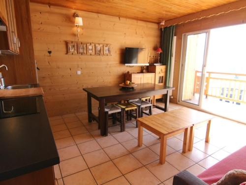 un salon avec une table et une cuisine dans l'établissement Studio cosy 4 pers avec balcon, face aux pistes et proche commerces – L'Alpe d'Huez - FR-1-405-44, à L'Alpe-d'Huez
