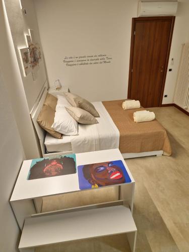 a room with a bed and a table with a book at GESUITIROOMS in Sona
