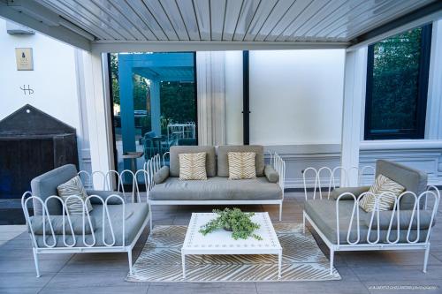a porch with two chairs and a couch and a table at LHP Hotel Montecatini Palace & SPA in Montecatini Terme