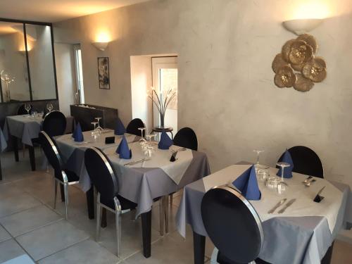 un comedor con mesas y sillas con servilletas azules en Hôtel Restaurant LE SAINT AUGUSTIN, en Saint-Amour