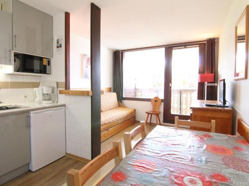 une cuisine et une salle à manger avec une table dans une pièce dans l'établissement Appartement cosy 6 pers. avec balcon, proche pistes et commerces - Alpe d'Huez - FR-1-405-99, à L'Alpe-d'Huez