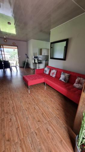 a living room with a red couch and a table at Vistaverdeboquete in Boquete