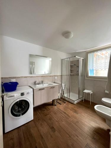 ein Badezimmer mit Waschmaschine und Waschbecken in der Unterkunft Magdalenablick in Villnöss