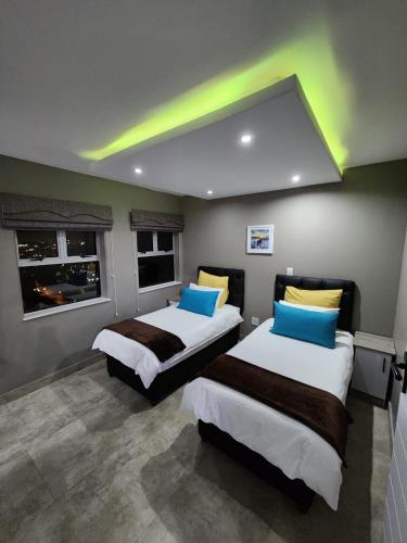 two beds in a room with lights on the ceilings at Durban Holiday Apartments , 1901 on High Tide in Amanzimtoti