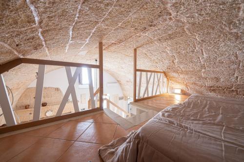 łóżko w pokoju z kamienną ścianą w obiekcie Casa a Santa Maria di Leuca w mieście Leuca