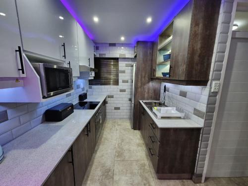 a large kitchen with a sink and a tv at Durban Holiday Apartments , 1901 on High Tide in Amanzimtoti