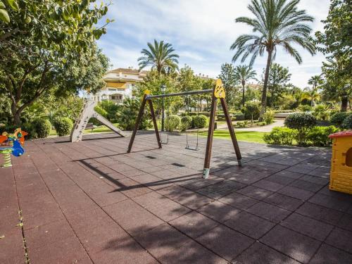 een schommel in een park met palmbomen bij Apartman La Concha in Puerto Banus in Marbella