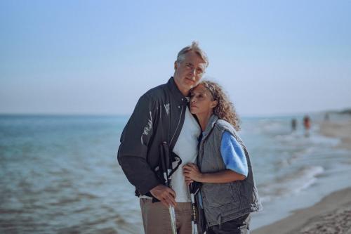 a man and a woman standing on the beach at Hotel Saltic Resort & Spa Grzybowo in Kołobrzeg