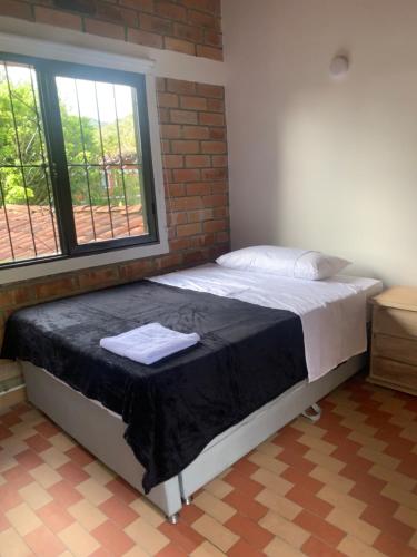 Ce lit se trouve dans une chambre dotée d'un mur en briques. dans l'établissement Villa Alejandra, à Guatapé
