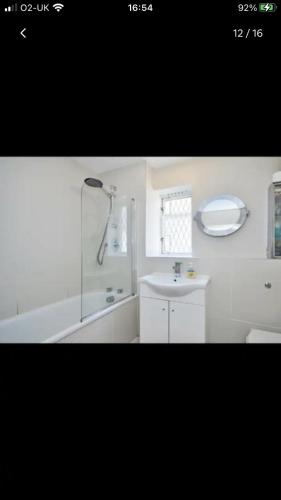 a white bathroom with a shower and a sink at Cosy central London flat Trafalgar Square in London
