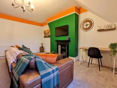 - un salon avec un canapé et un mur vert dans l'établissement The Akenside, à Jesmond