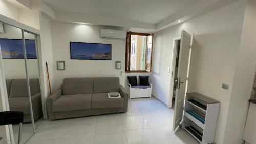 ein Wohnzimmer mit einem Sofa und einem Stuhl in der Unterkunft Studio rue piétonne proche plage in Menton