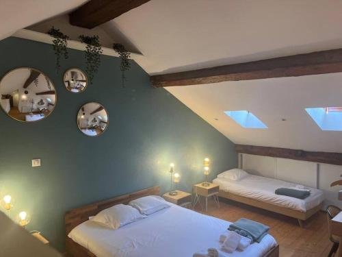 a bedroom with two beds and two mirrors on the wall at L'escalier du Château T4 Duplex 9 couchages 4* in Annecy