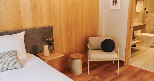 a bedroom with a bed and a chair and a bathroom at Casa Izeba in Mexico City