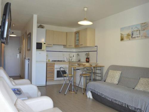un salon avec un canapé et une cuisine dans l'établissement Cap d'Agde: Appt 2 pièces cabine, 6 couchages, proche plage, loggia, parking - FR-1-249-127, au Cap d'Agde
