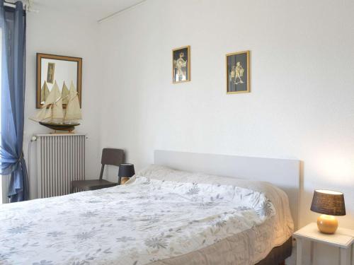 une chambre avec un lit et deux tableaux au mur dans l'établissement Cap d'Agde: Appt 2 pièces cabine, 6 couchages, proche plage, loggia, parking - FR-1-249-127, au Cap d'Agde