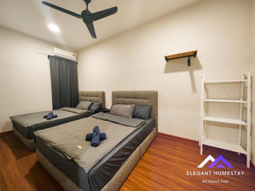two beds in a bedroom with a ceiling fan at Mosaic Southkey Midvelly By Elegant Johor Bahru in Johor Bahru