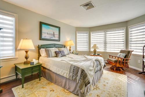 a bedroom with a bed and a chair and windows at New Jersey Home - Deck, Grill and Walkable to Beach! in Ship Bottom