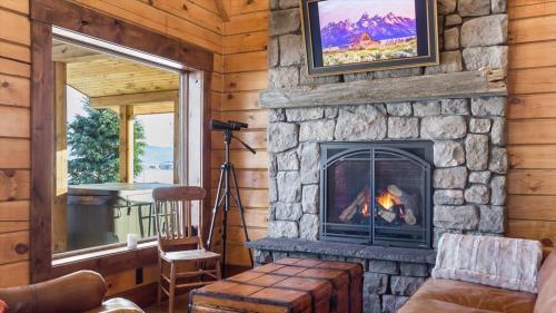 a living room with a fireplace and a tv at Targhee Shadows - Tetons Yellowstone hot tub in Tetonia