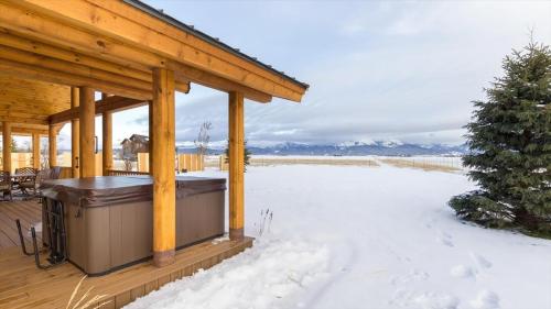 a covered deck with a hot tub in the snow at Targhee Shadows - Tetons Yellowstone hot tub in Tetonia