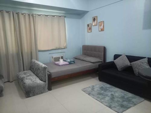 Morgan Suite Hotel في مانيلا: غرفة معيشة مع سرير وكرسي