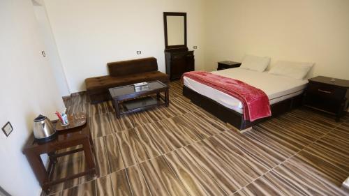 a hotel room with a bed and a table and a bed sidx sidx at Al Namteh Lodge in ‘Ābil
