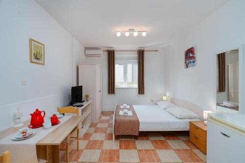 a white room with a bed and a table at Apartments Family Gligora in Mandre