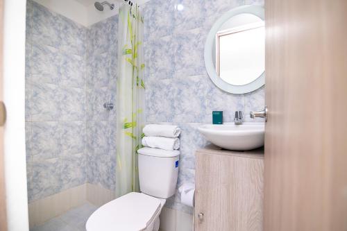 a bathroom with a toilet and a sink and a mirror at Hotel Esperanza AC in Cartagena de Indias
