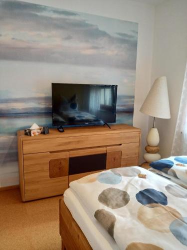 a bedroom with a tv on top of a dresser at Ehem. Sächsisch-Bayrischer Hof in Pöhl