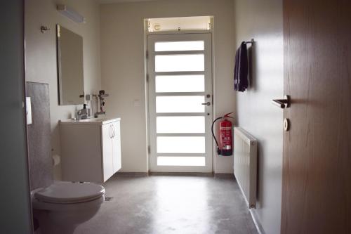 bagno con servizi igienici, lavandino e porta di The Organist House in Golden Circle a Skálholt