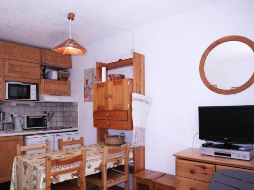 une cuisine avec une table, une télévision et une salle à manger dans l'établissement Skis aux pieds! Superbe studio 6 pers., proche station, balcon Sud Ouest, tout équipé - FR-1-322-290, aux Orres