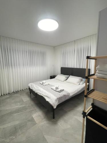 1 dormitorio con 1 cama en una habitación con cortinas en הטרקלין של לינוי - 5 דקות נסיעה מהים en Ashqelon
