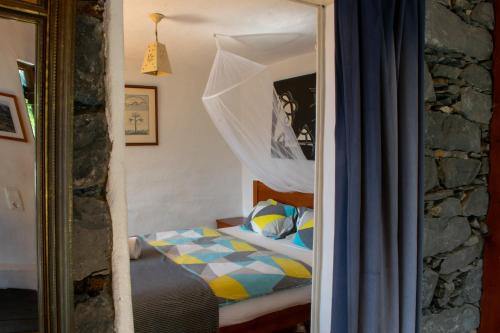 a bedroom with a bed with a curtain and a mirror at Unique House - Pool, Terrace & Amazing View in Ribeira Brava