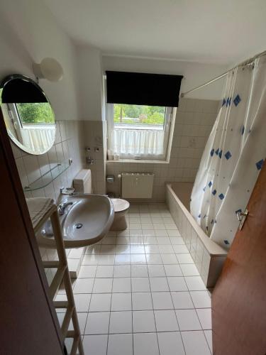 W łazience znajduje się umywalka, toaleta i prysznic. w obiekcie 2-Zimmer Monteurwohnung mit großem Balkon w Kilonii