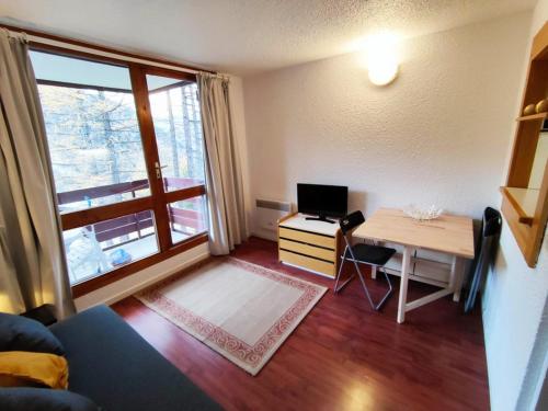 Cette petite chambre comprend un bureau avec un ordinateur et une fenêtre. dans l'établissement Charmant studio au calme avec balcon et internet - FR-1-292-108, à Isola 2000