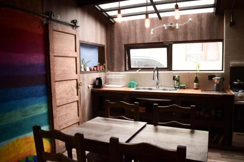 uma cozinha com uma mesa e uma cozinha com um lavatório em Habitación privada en casa compartida em San Carlos de Bariloche