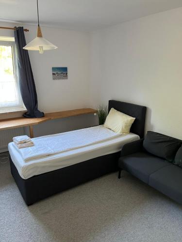 łóżko i kanapa w pokoju w obiekcie 2-Zimmer Monteurwohnung mit großem Balkon w Kilonii