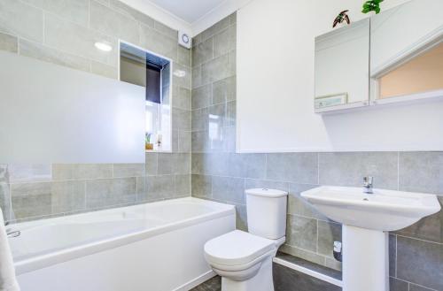 a bathroom with a white toilet and a sink at Modern 2 Bedroom Apartment in Romford