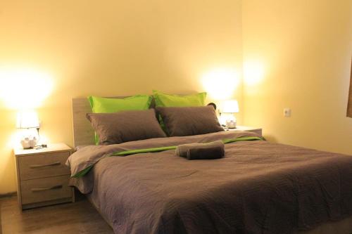 a bedroom with a large bed with green pillows at Hotel Tbilisi sea Terrace in Tbilisi City