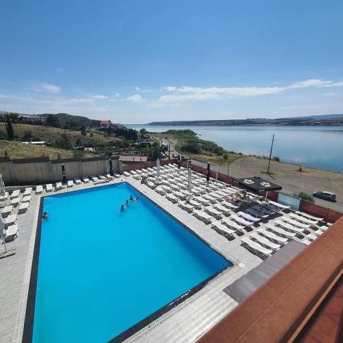 a swimming pool with lounge chairs and a view of the water at Hotel Tbilisi sea Terrace in Tbilisi City