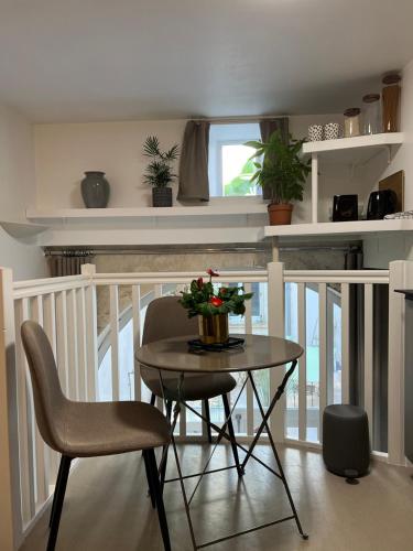 une table à manger avec des chaises et une table avec des fleurs dans l'établissement Agréable Studio au Centre Ville, à La Rochelle