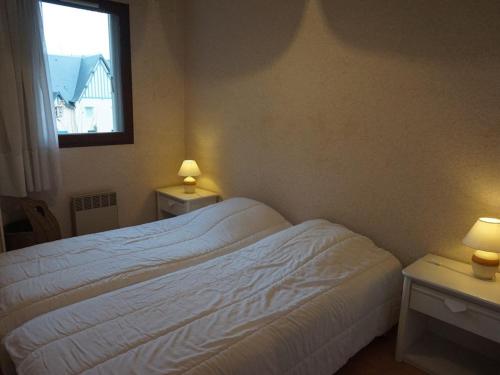 ein Schlafzimmer mit einem Bett und zwei Tischen mit Lampen in der Unterkunft Appartement Cabourg, 2 pièces, 4 personnes - FR-1-465-21 in Cabourg
