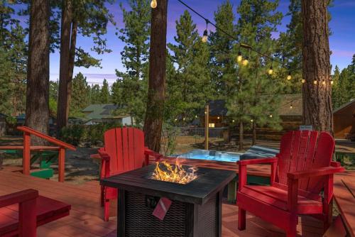 Un patio con dos sillas rojas y una fogata. en Mountain Getaway, en Big Bear Lake
