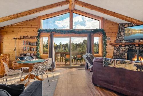 a living room with a large window in a log cabin at Bearadise Retreat in Big Bear Lake