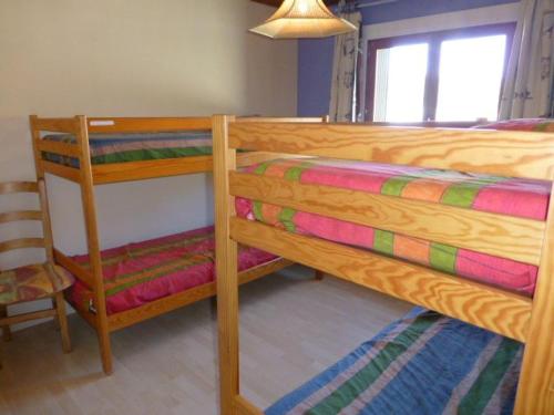 - une chambre avec 2 lits superposés et une chaise dans l'établissement Appartement confortable 3P6P près des pistes à L'Alpe d'Huez - FR-1-405-1, à L'Alpe-d'Huez