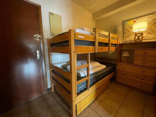 two bunk beds in a room with a door at Appartement Huez, 1 pièce, 4 personnes - FR-1-405-11 in L'Alpe-d'Huez