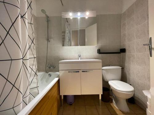 a bathroom with a sink and a toilet and a tub at Appartement Huez, 1 pièce, 4 personnes - FR-1-405-11 in L'Alpe-d'Huez