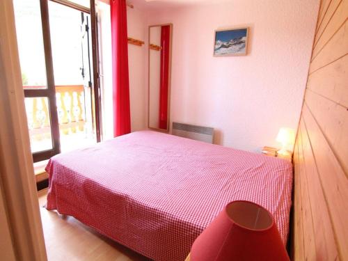 uma cama vermelha num quarto com uma janela em Appartement Huez, 2 pièces, 6 personnes - FR-1-405-27 em Alpe-d'Huez