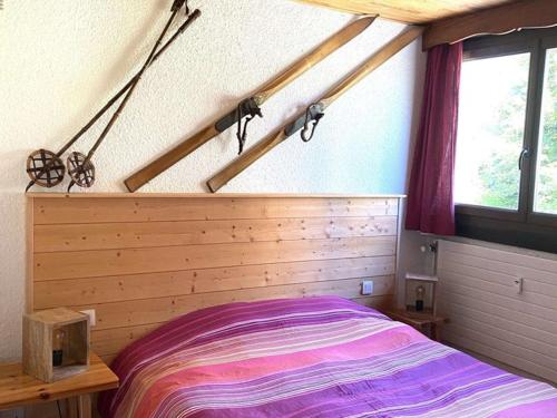une chambre avec un lit avec une tête de lit en bois dans l'établissement Spacieux T2 pour 6-8 pers, face pistes, proche commerces - L'Alpe d'Huez - FR-1-405-29, à L'Alpe-d'Huez